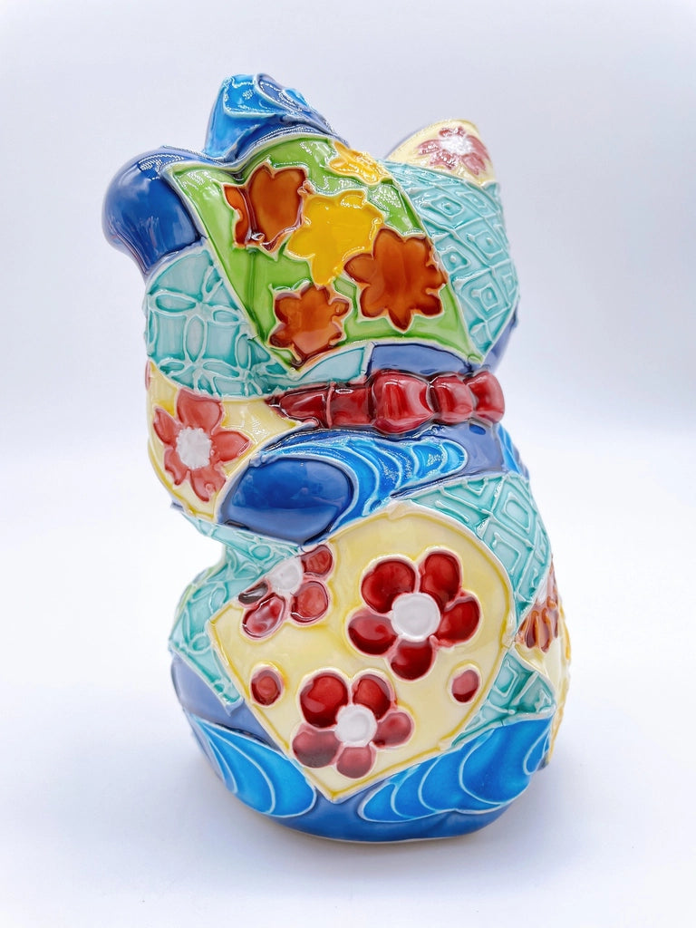 Japanese Kiyomizu-style Maneki-neko (lucky cat) with cross-colored dark blue background and floral pattern.
