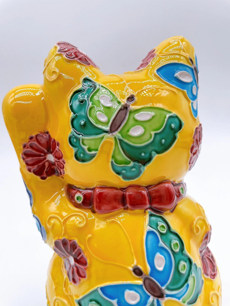 Japanese Kiyomizu-style lucky cat saucer with a yellow background and floral design.