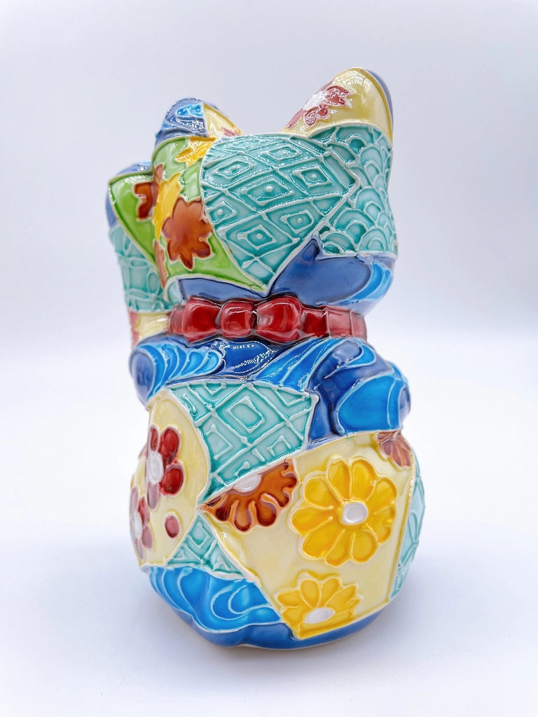 Japanese Kiyomizu-style Maneki-neko (lucky cat) with cross-colored dark blue background and floral pattern.