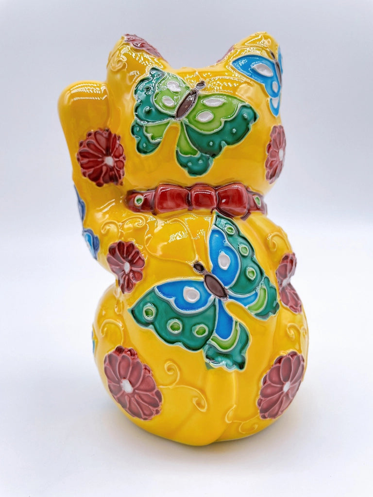 Japanese Kiyomizu-style lucky cat saucer with a yellow background and floral design.
