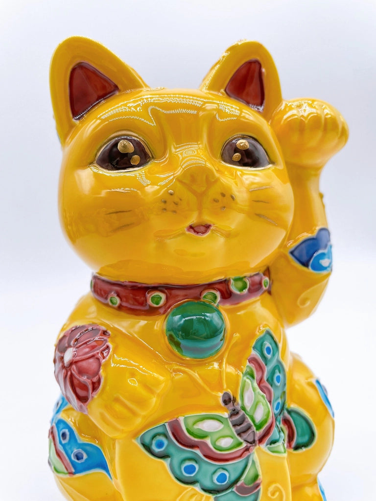 Japanese Kiyomizu-style lucky cat saucer with a yellow background and floral design.