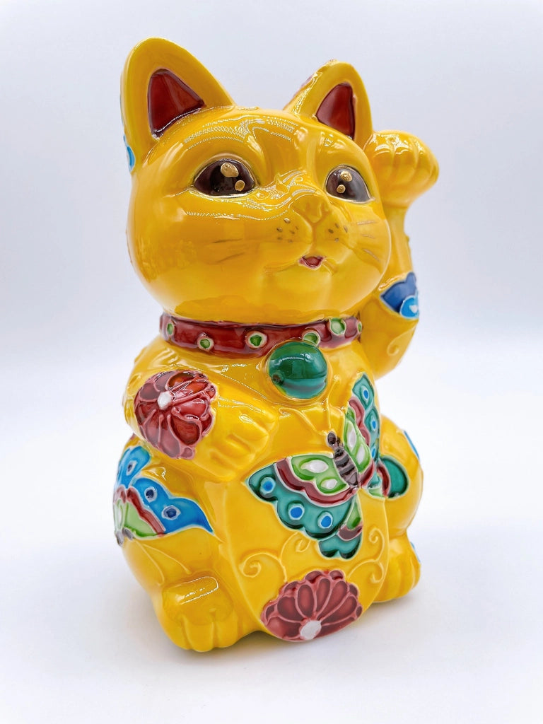 Japanese Kiyomizu-style lucky cat saucer with a yellow background and floral design.