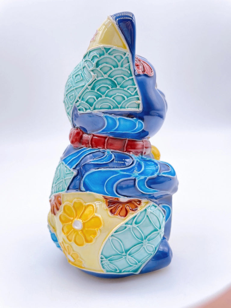 Japanese Kiyomizu-style Maneki-neko (lucky cat) with cross-colored dark blue background and floral pattern.