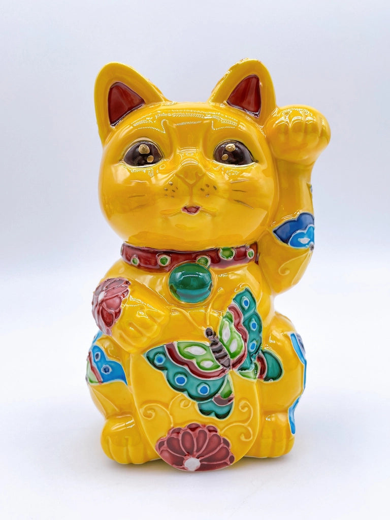 Japanese Kiyomizu-style lucky cat saucer with a yellow background and floral design.